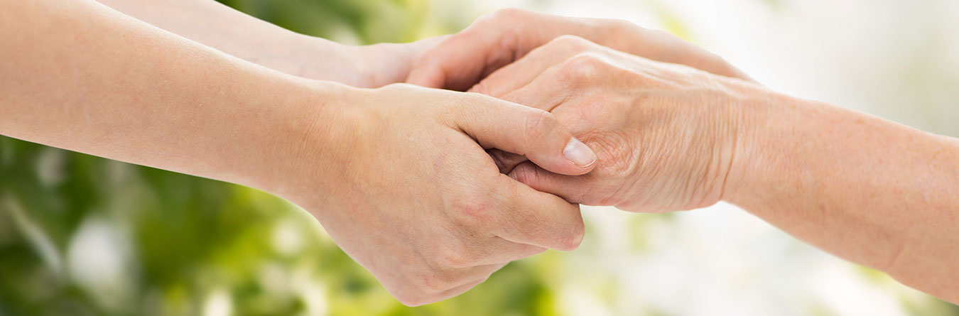 younger person holding hands with older person
