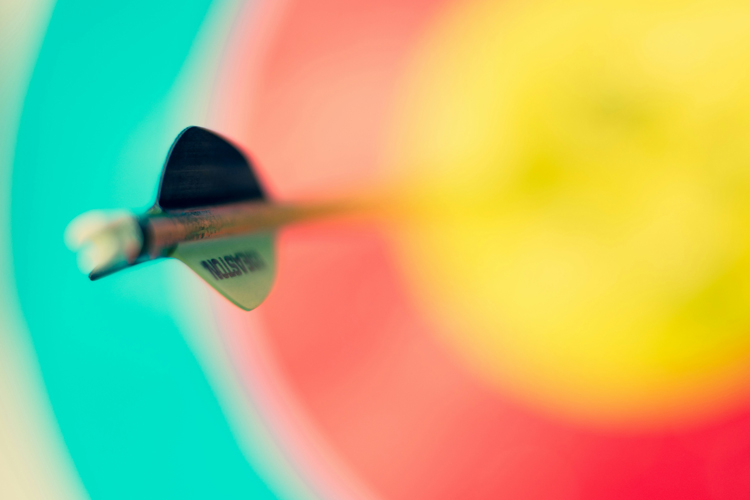 close-up of dart on the bullseye of a dart board