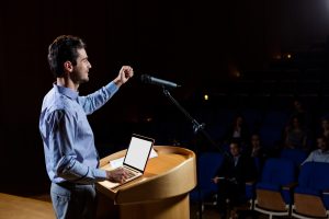Male business executive giving a speech at conference center