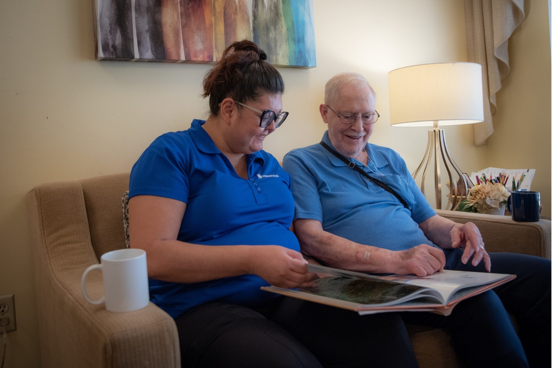 team member and older man looking at book 2 landscape