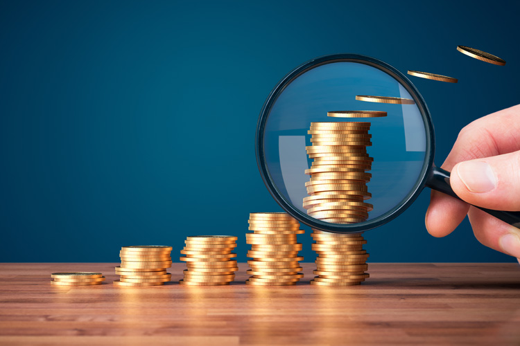 cdms magnifying glass focused on stack of coins